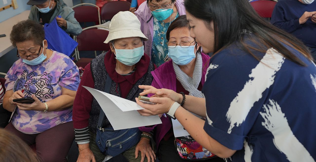 Group of Asian women wearing masks learning about smartphone technology